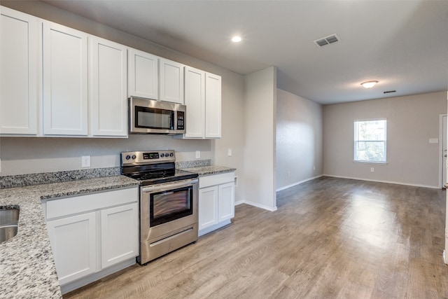 kitchen featuring white cabinets, light hardwood / wood-style flooring, light stone countertops, and stainless steel appliances