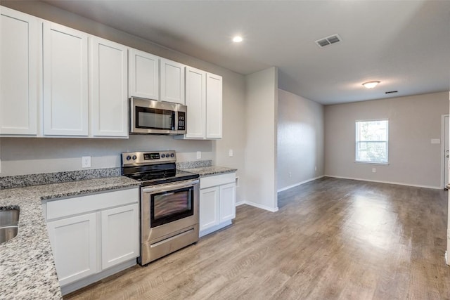 kitchen featuring open floor plan, white cabinetry, light wood-type flooring, visible vents, and appliances with stainless steel finishes