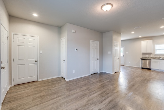 unfurnished living room featuring light hardwood / wood-style floors and sink