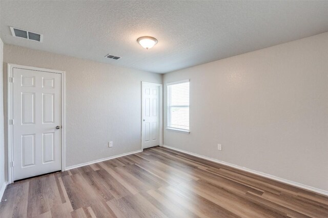 8236 Brucks Dr, San Antonio, TX 78244 - unfurnished bedroom featuring wood finished floors and a textured ceiling