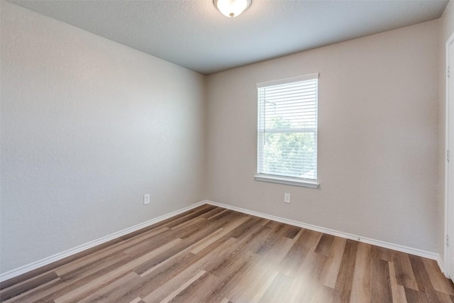 empty room featuring baseboards and wood finished floors