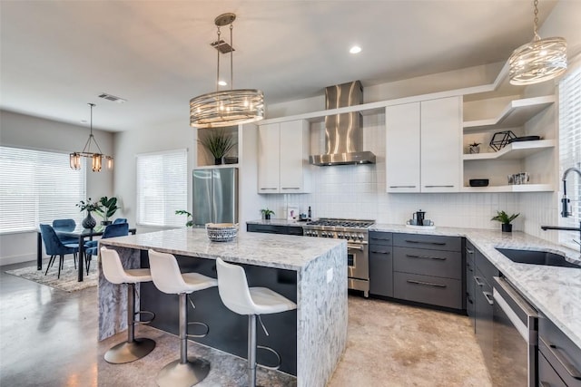 kitchen with gray cabinetry, stainless steel appliances, open shelves, white cabinetry, and wall chimney exhaust hood