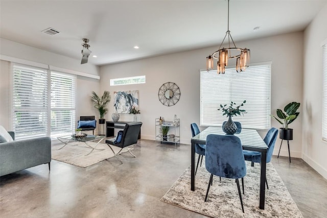 dining space with visible vents, a notable chandelier, finished concrete flooring, and baseboards