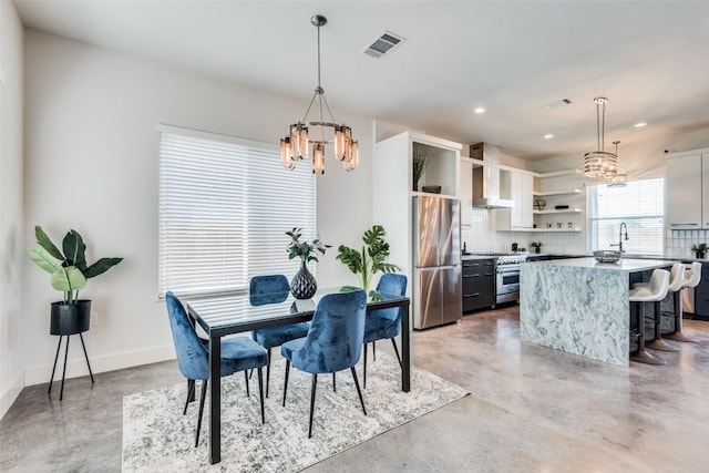 dining area featuring a chandelier, baseboards, visible vents, and concrete flooring