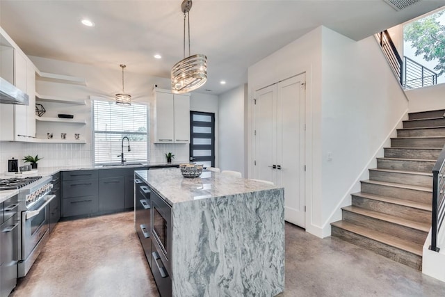 kitchen featuring a center island, finished concrete flooring, open shelves, stainless steel appliances, and white cabinets