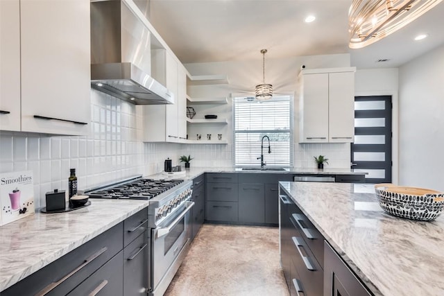 kitchen featuring high end stove, a sink, white cabinetry, wall chimney range hood, and open shelves