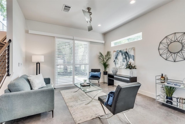 living area with concrete floors, recessed lighting, visible vents, and baseboards