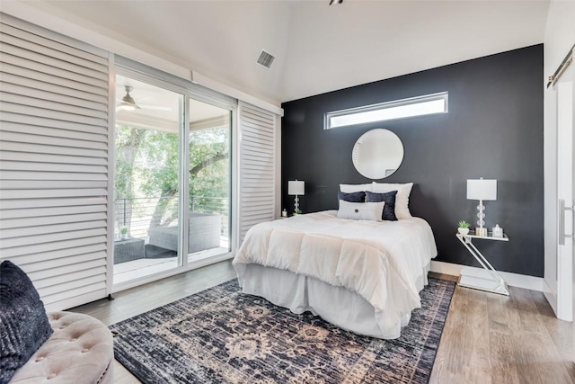 bedroom featuring access to exterior, visible vents, baseboards, and wood finished floors