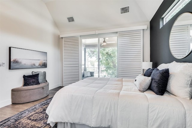 bedroom with lofted ceiling, baseboards, visible vents, and wood finished floors