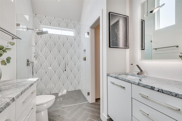 full bath with a shower stall, vanity, and toilet