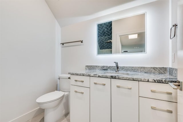 bathroom with toilet, baseboards, and vanity