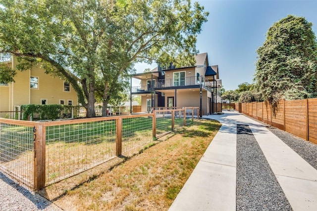 view of front of property featuring stairs, a fenced front yard, and a balcony