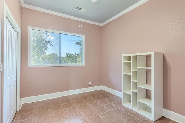 empty room featuring light tile patterned flooring and crown molding