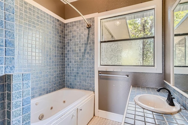 bathroom with tiled shower / bath combo, tile patterned floors, and sink