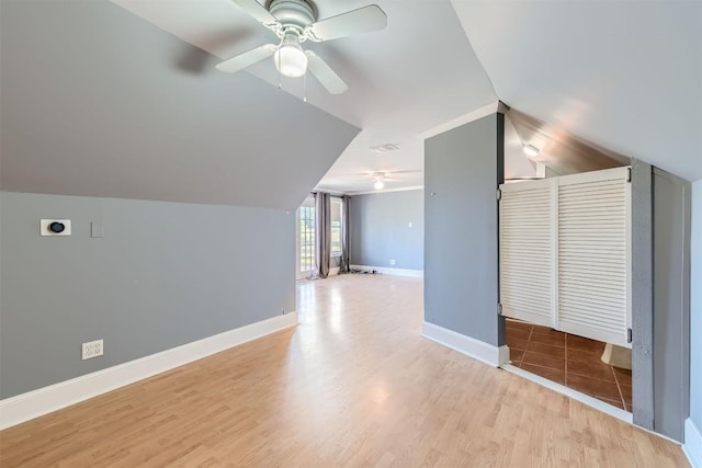 additional living space with ceiling fan, light hardwood / wood-style floors, and vaulted ceiling