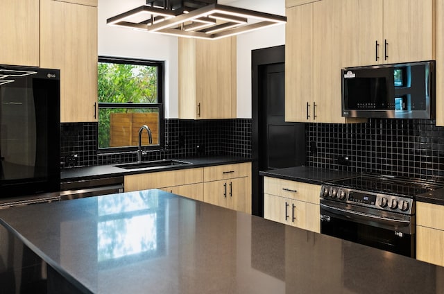 kitchen featuring appliances with stainless steel finishes, light brown cabinets, decorative backsplash, and sink