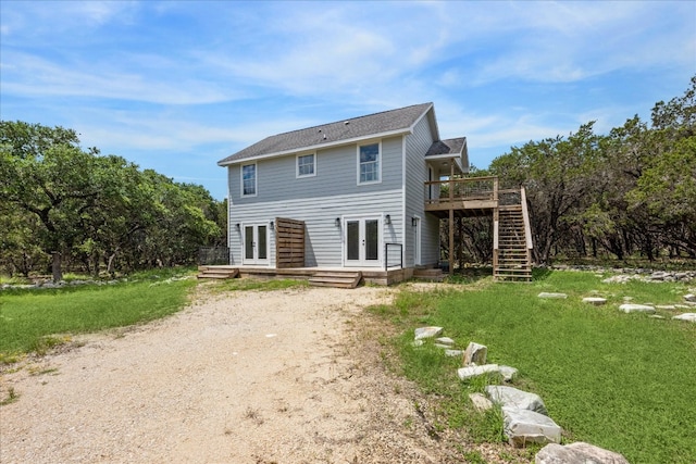 back of house featuring a deck and a lawn