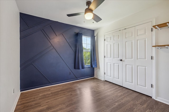 unfurnished bedroom with ceiling fan, a closet, and wood-type flooring