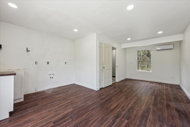 empty room with hardwood / wood-style flooring, an AC wall unit, and radiator