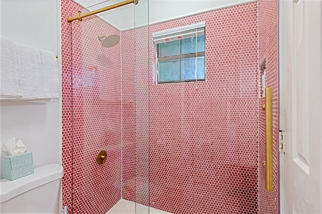 bathroom featuring toilet and a tile shower