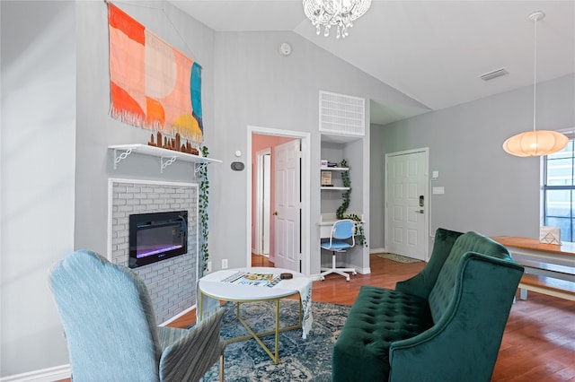 living room with a fireplace, high vaulted ceiling, a chandelier, and wood-type flooring