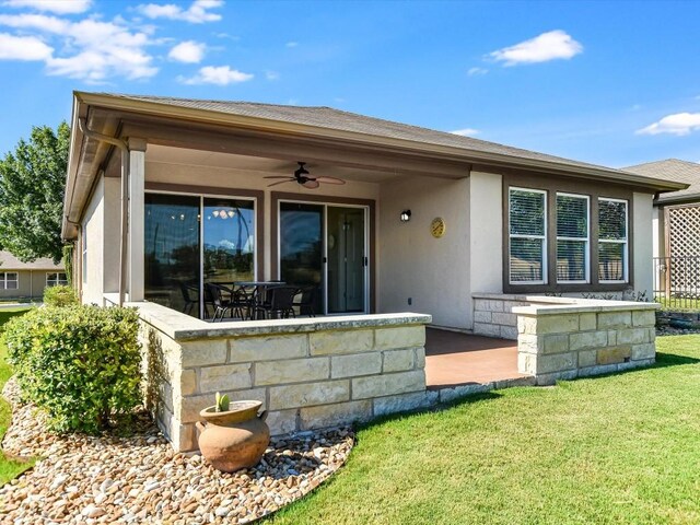 rear view of property with a patio, a lawn, and ceiling fan