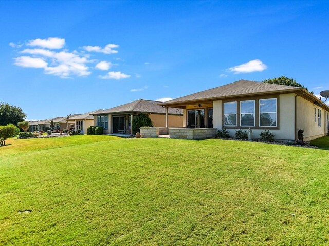 back of property featuring a patio area and a lawn