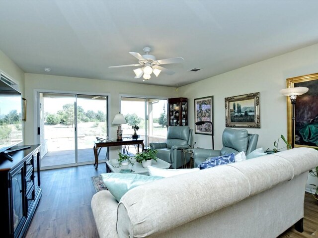 living room featuring dark wood-type flooring and ceiling fan