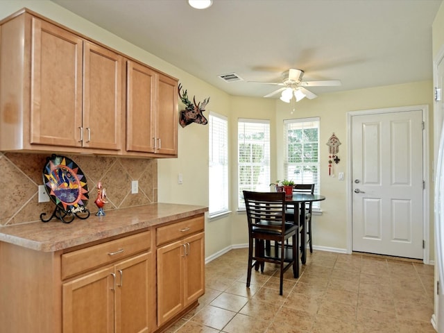 kitchen with ceiling fan, light tile patterned floors, and tasteful backsplash