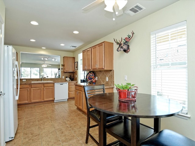 kitchen with backsplash, sink, white appliances, and plenty of natural light