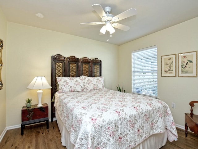 bedroom with dark hardwood / wood-style flooring and ceiling fan