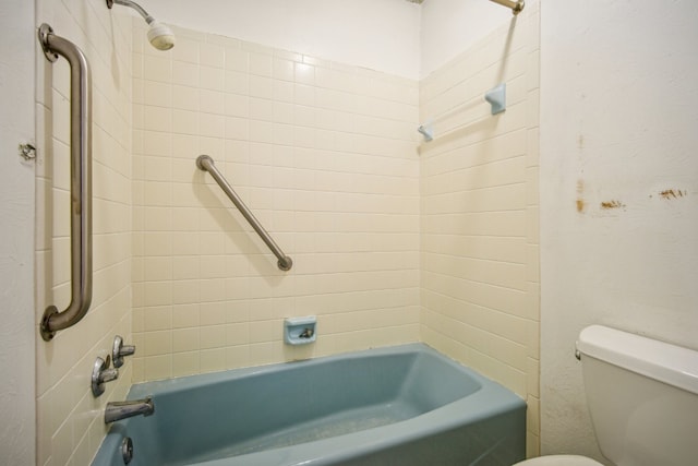 bathroom with tiled shower / bath combo and toilet