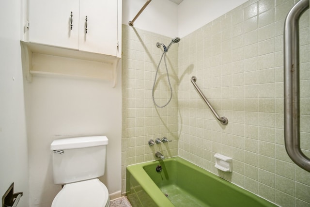 bathroom featuring toilet and tiled shower / bath