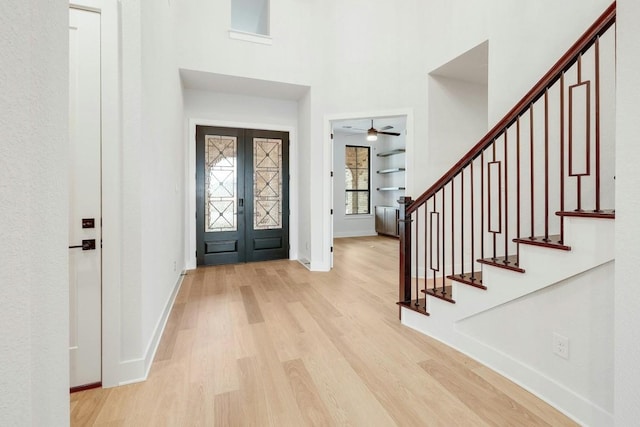 entryway with ceiling fan, light hardwood / wood-style floors, and french doors