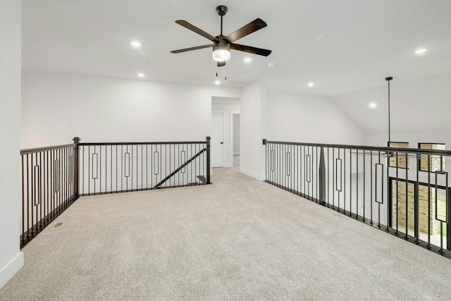 unfurnished room with ceiling fan, light colored carpet, and vaulted ceiling