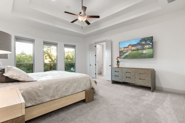 bedroom featuring a tray ceiling, ceiling fan, and light colored carpet