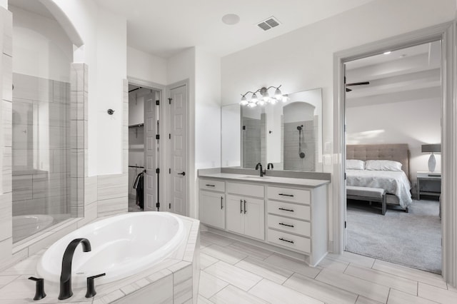 bathroom featuring tile patterned flooring, independent shower and bath, and vanity