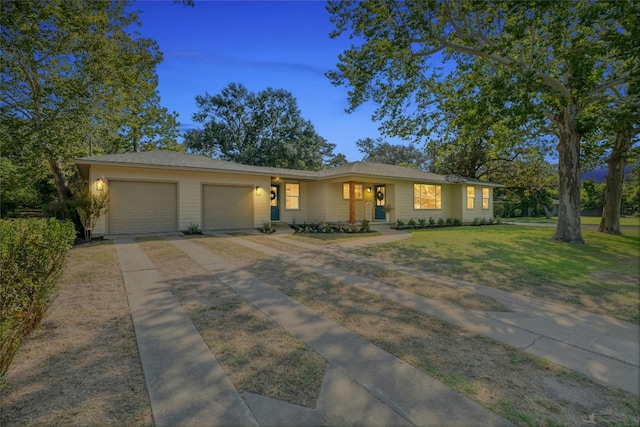 ranch-style house featuring a garage and a yard