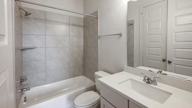 full bathroom with vanity, tiled shower / bath combo, and toilet