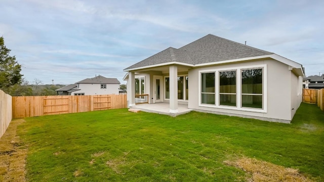 rear view of house with a yard and a patio