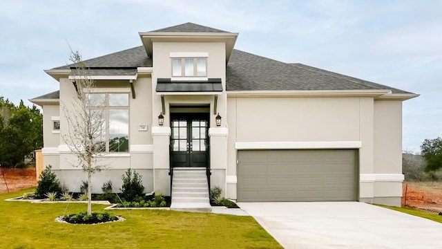 prairie-style house with french doors, a front yard, and a garage