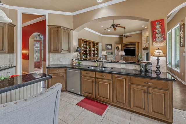 kitchen featuring stainless steel dishwasher, ornamental molding, sink, and tasteful backsplash