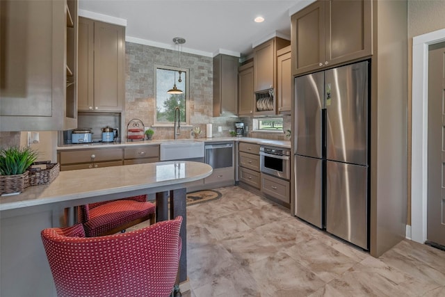 kitchen with tasteful backsplash, sink, hanging light fixtures, stainless steel appliances, and crown molding