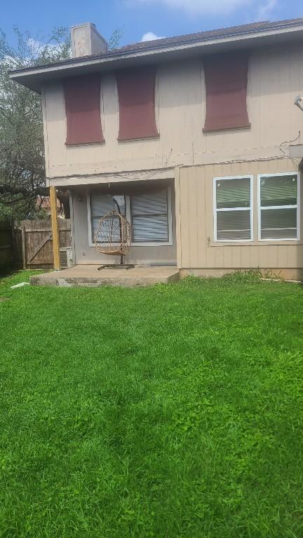 back of house with fence and a yard