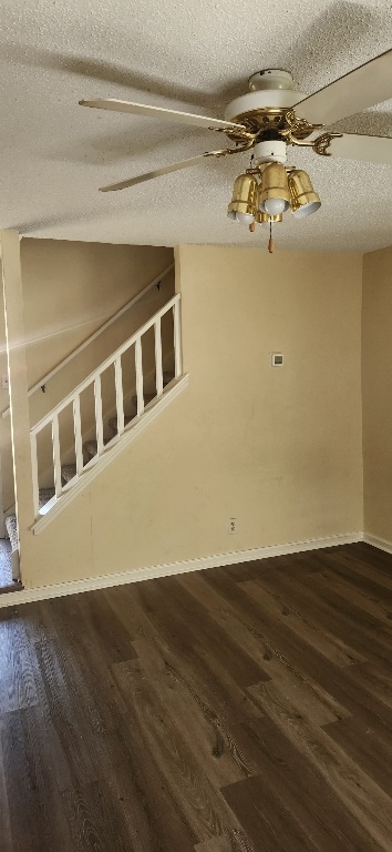 empty room featuring dark wood-style floors, ceiling fan, baseboards, and a textured ceiling