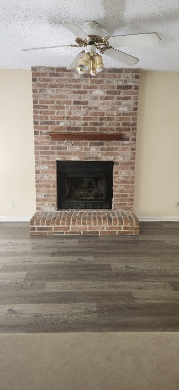 room details with a brick fireplace, baseboards, a textured ceiling, a ceiling fan, and wood finished floors