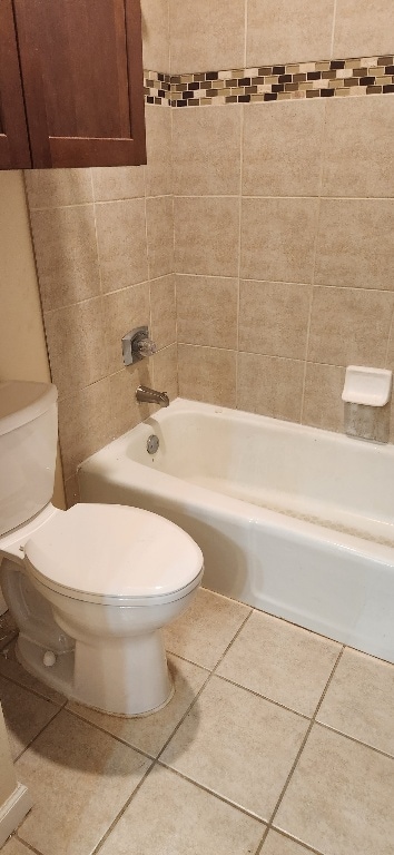 full bath featuring shower / tub combination, tile patterned flooring, and toilet