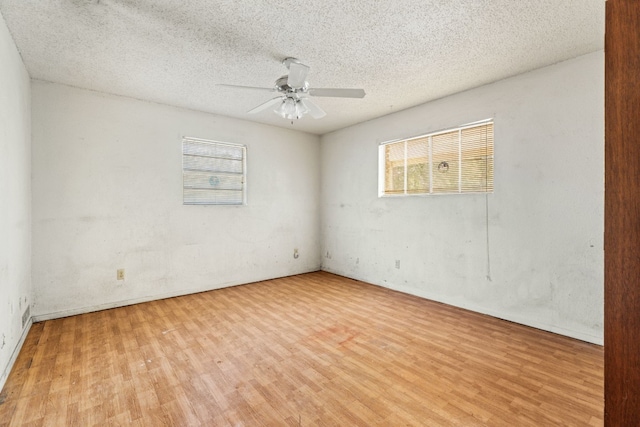 spare room featuring wood finished floors, ceiling fan, and a textured ceiling