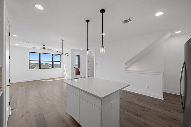 kitchen featuring hardwood / wood-style floors, a center island, white cabinets, ceiling fan, and decorative light fixtures