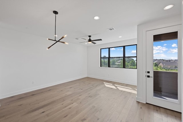 unfurnished room featuring light wood-type flooring and a chandelier